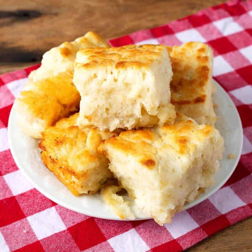Butter Dip Biscuits stacked on a white plate