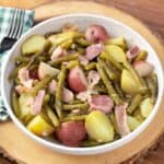 Southern Green Beans Bacon Potatoes in a white bowl on wood