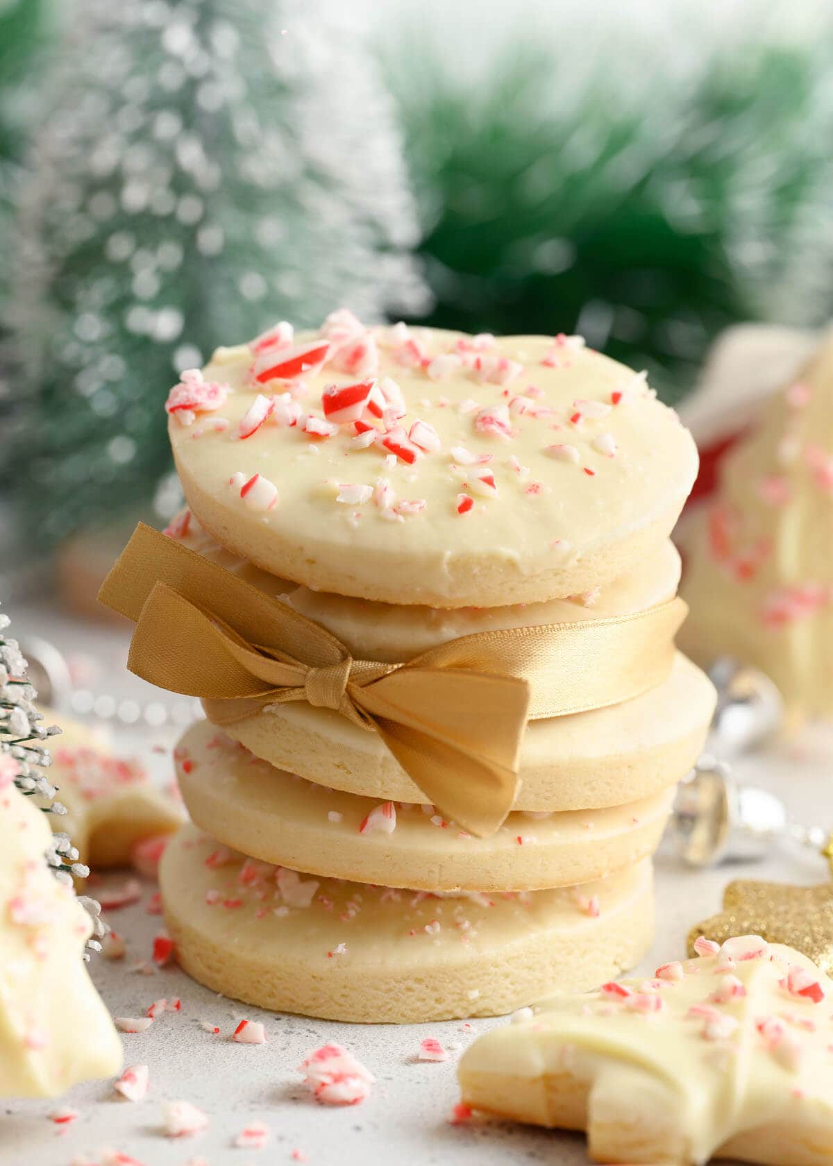 stack of Christmas Cut Out Sugar Cookies with ribbon and candy