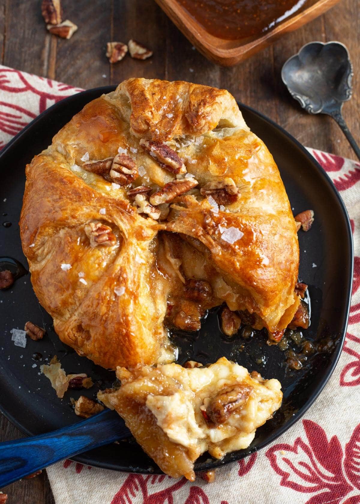 Easy Baked Brie in Puff Pastry cut open on black plate