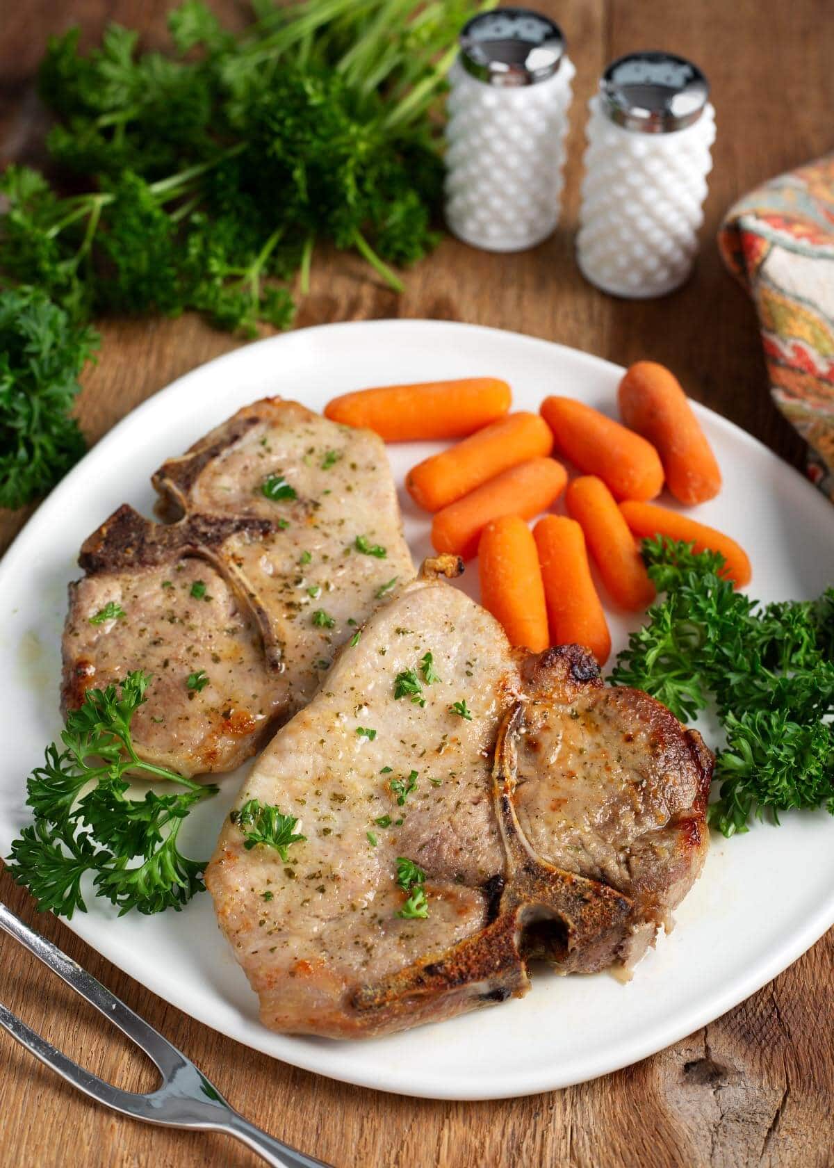Baked Ranch Pork Chops on a white plate with vegetables