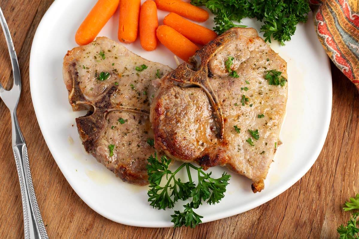 Baked Ranch Pork Chops on a white plate with vegetables
