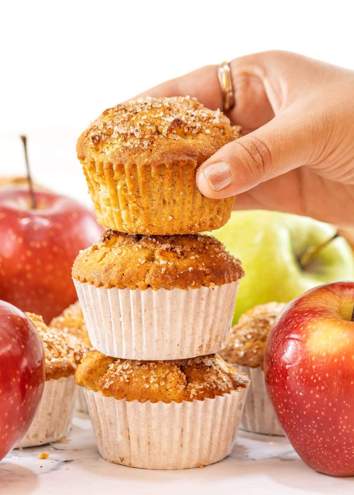 Cinnamon Apple Muffins stacked with hand on one