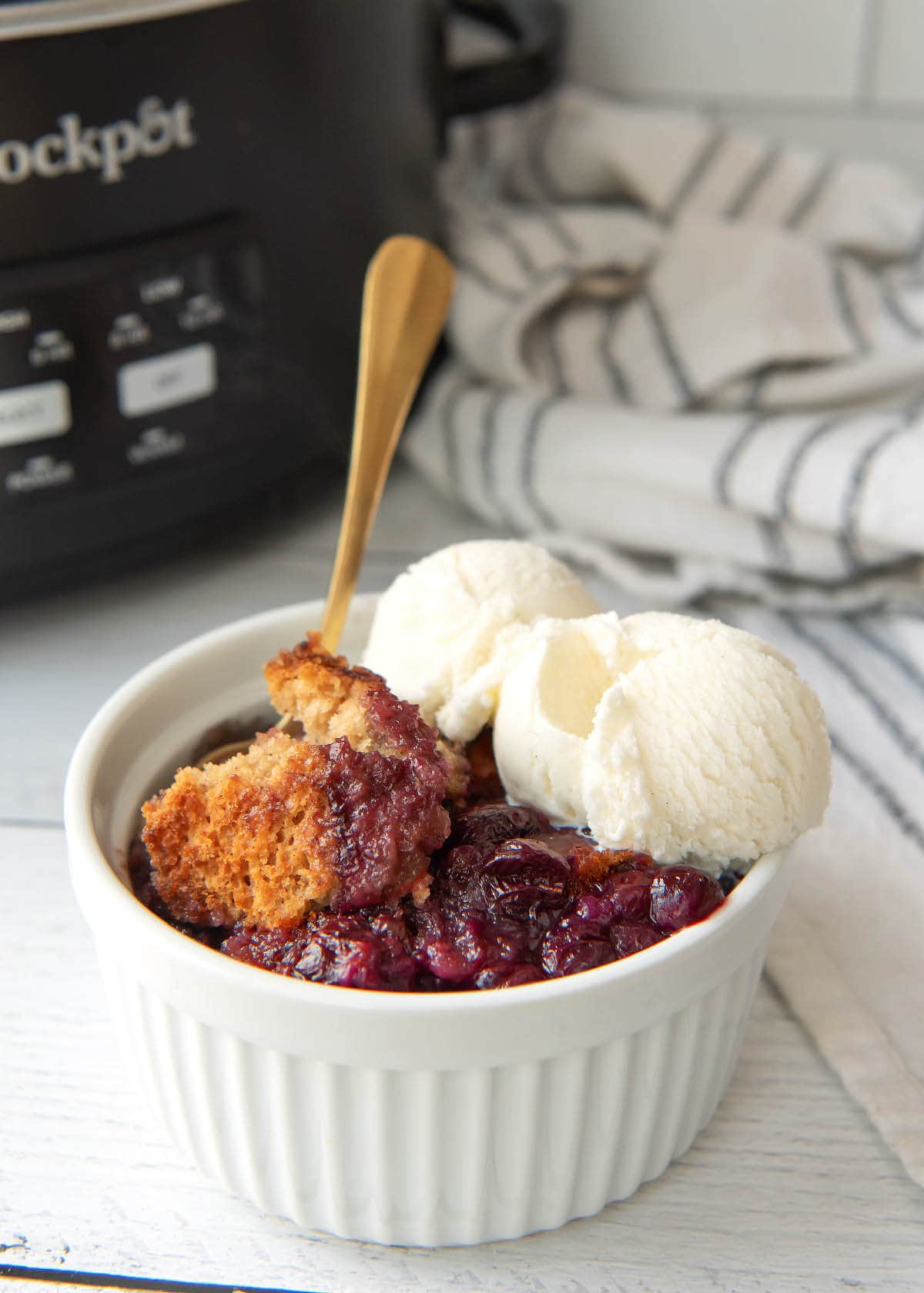 Slow Cooker Blueberry Cobbler in white bowl with ice cream.