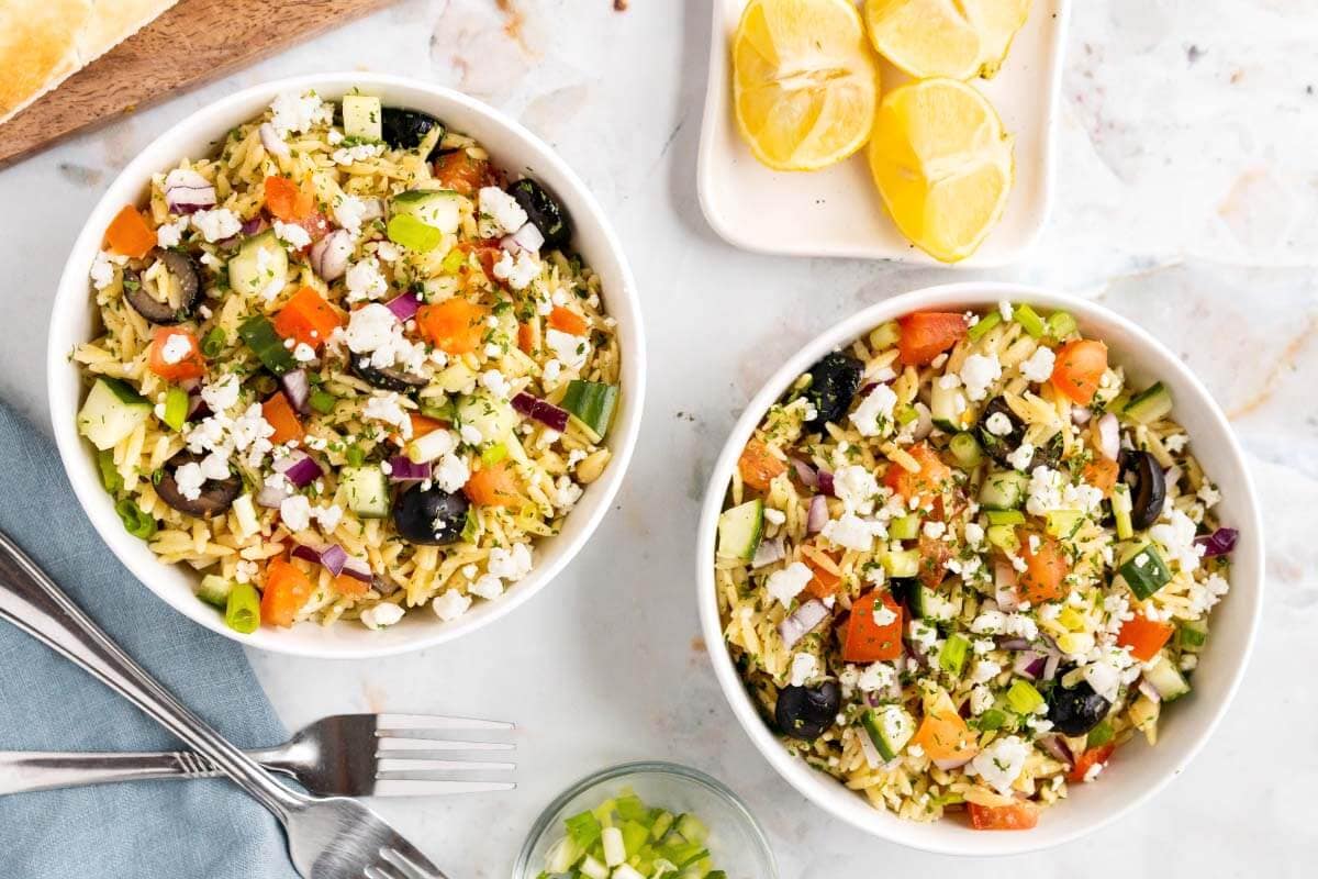 two white bowls of pasta salad