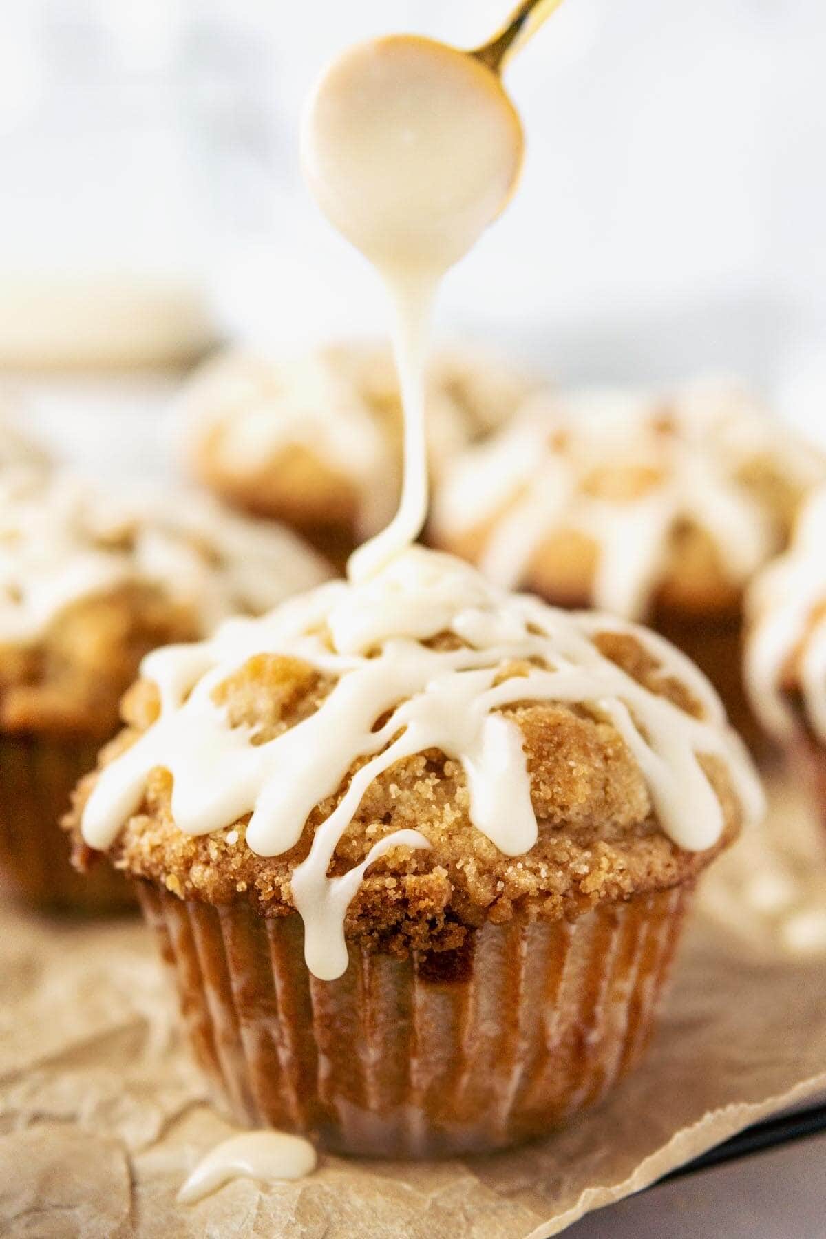 Oatmeal Chocolate Chip Muffins with Streusel Topping and icing being drizzled on top