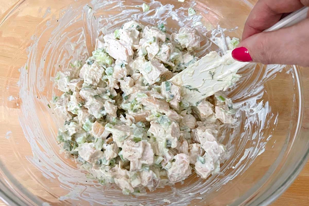 chicken salad being mixed in a bowl.