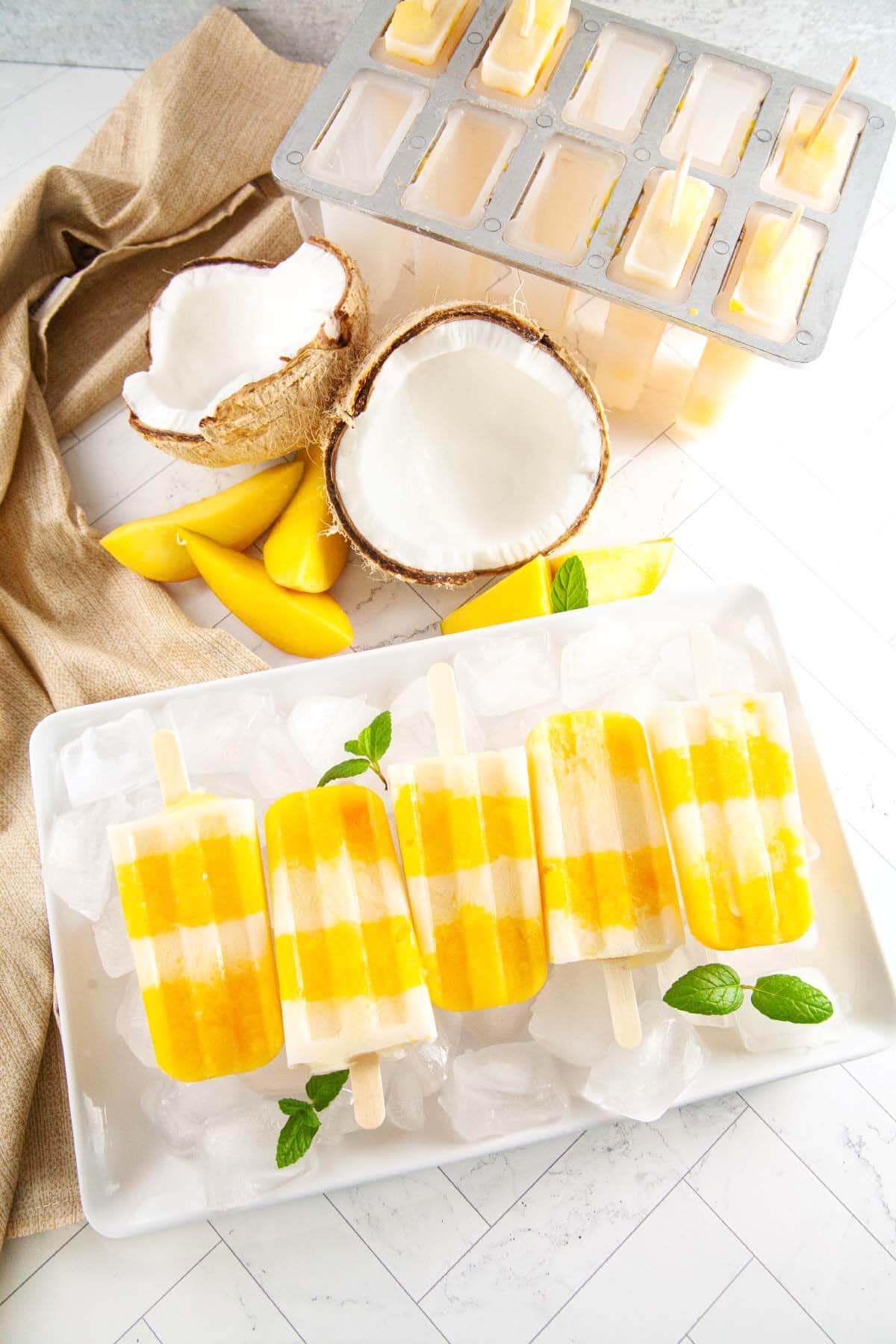 Mango Popsicles on a white tray.