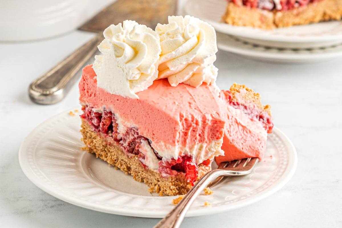 slice of raspberry cheesecake on a white plate.