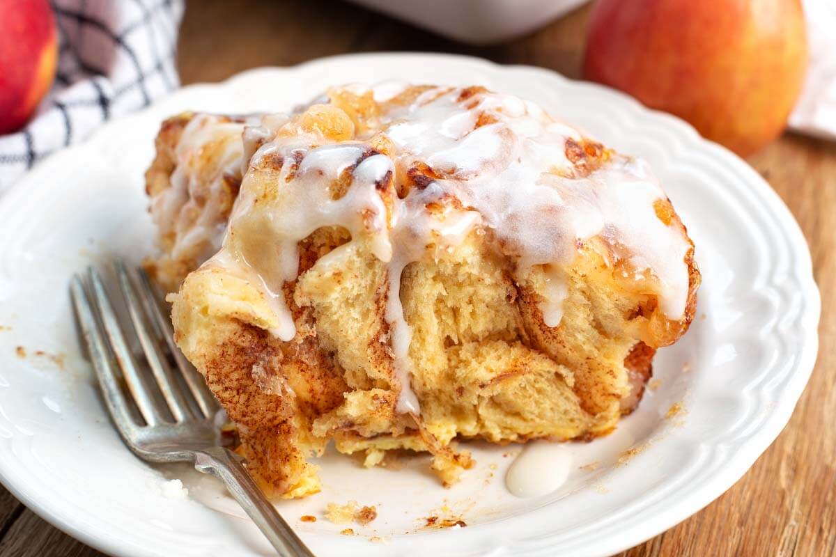 serving of apple cinnamon roll casserole on a white plate.