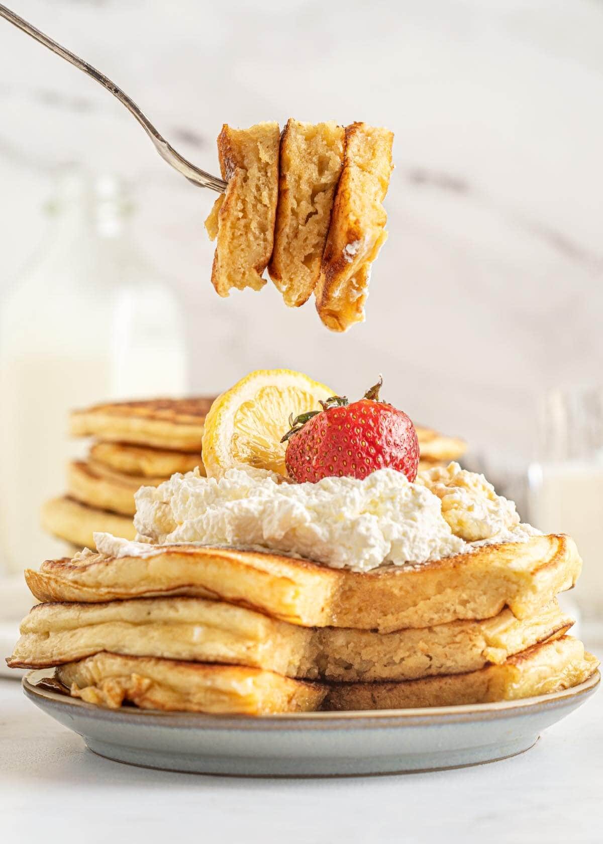 stack of Lemon Ricotta Pancakes and a bite on a fork.
