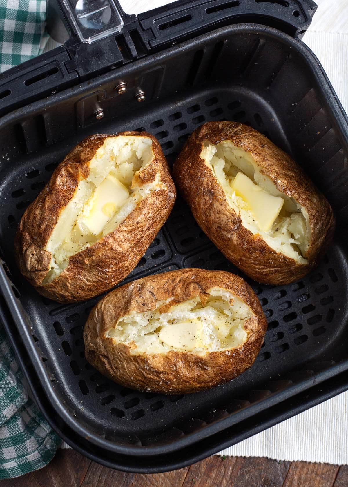 3 Air Fryer Baked Potatoes in basket.