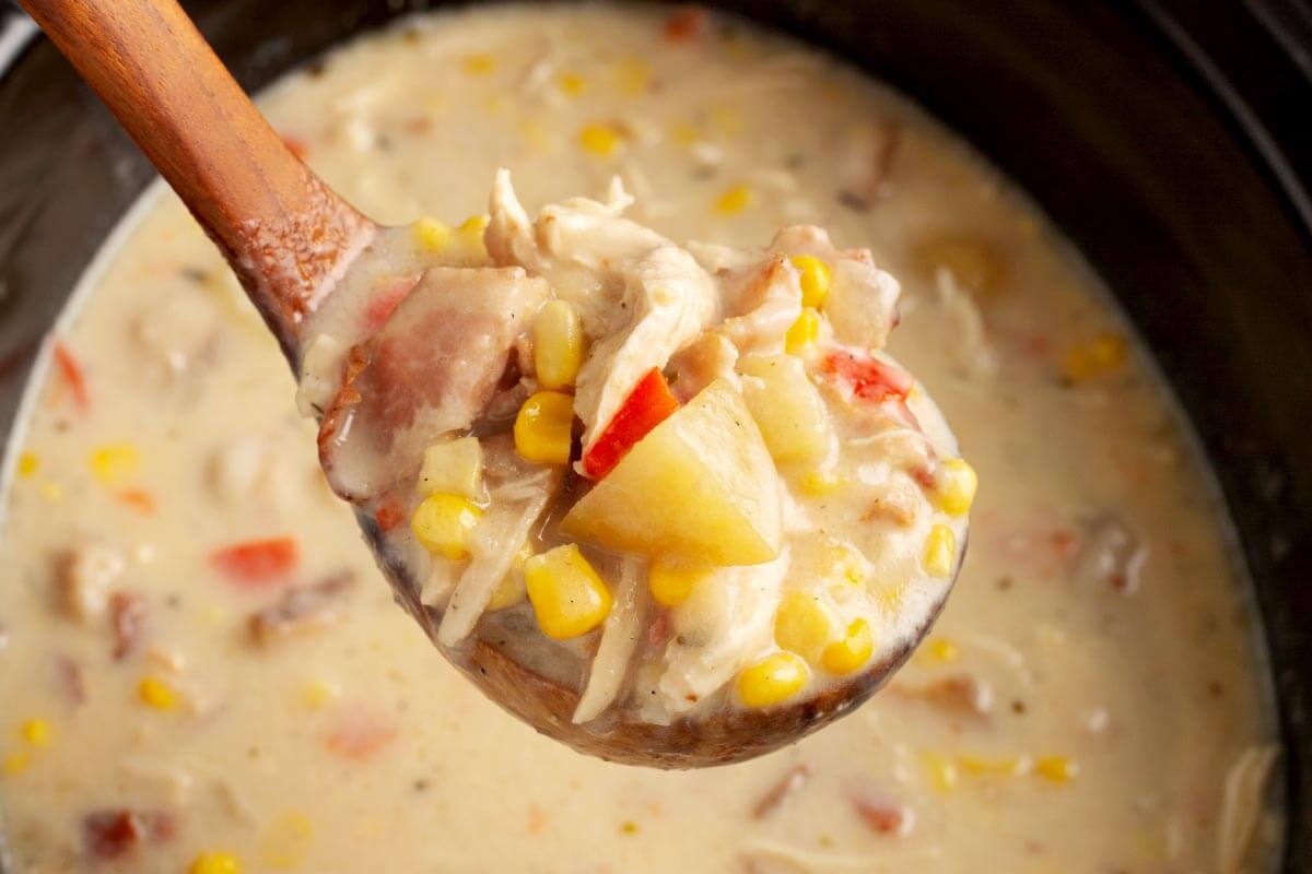 Slow Cooker Chicken Corn Chowder in a wooden ladle.