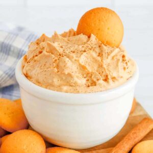 pumpkin fluff dip in a white bowl with cookies around.