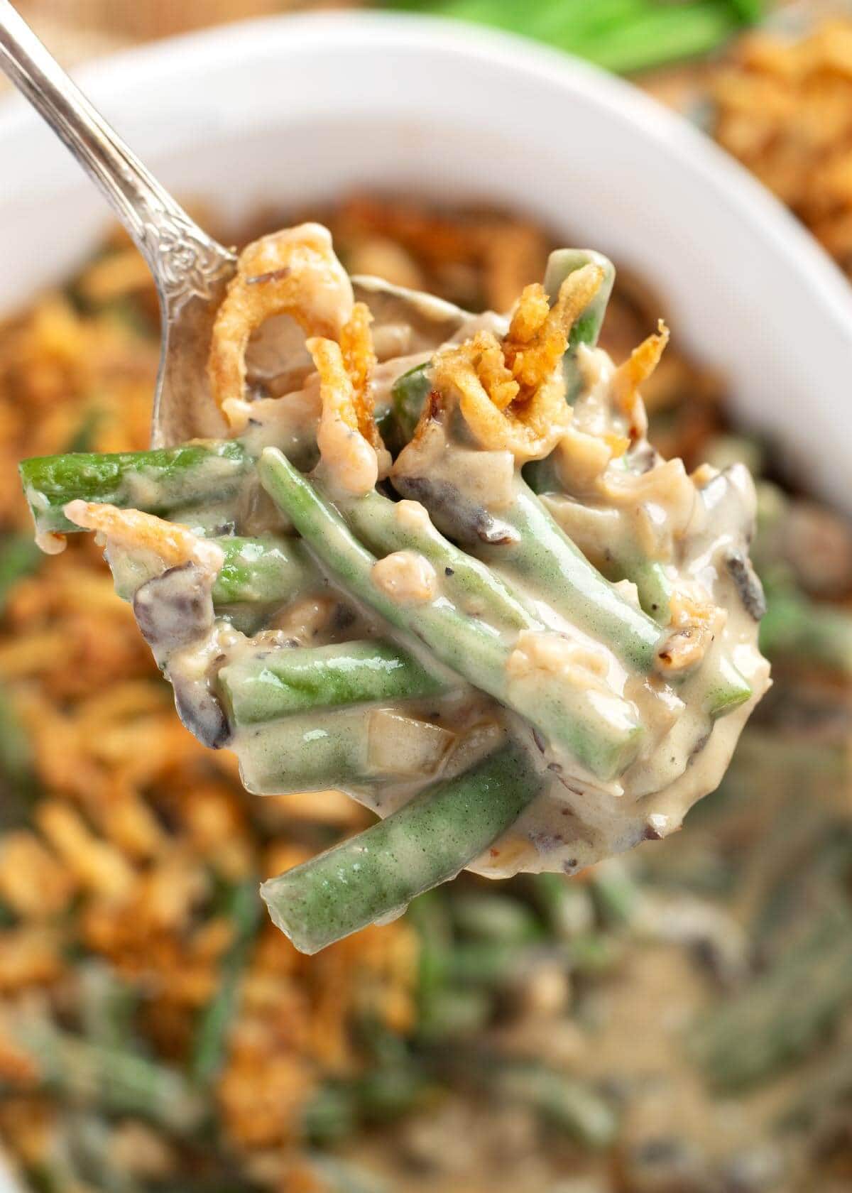fork with a bite of green beans casserole on it.