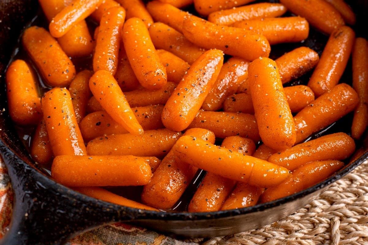 Buttery Brown Sugar Glazed Carrots in cast iron skillet.