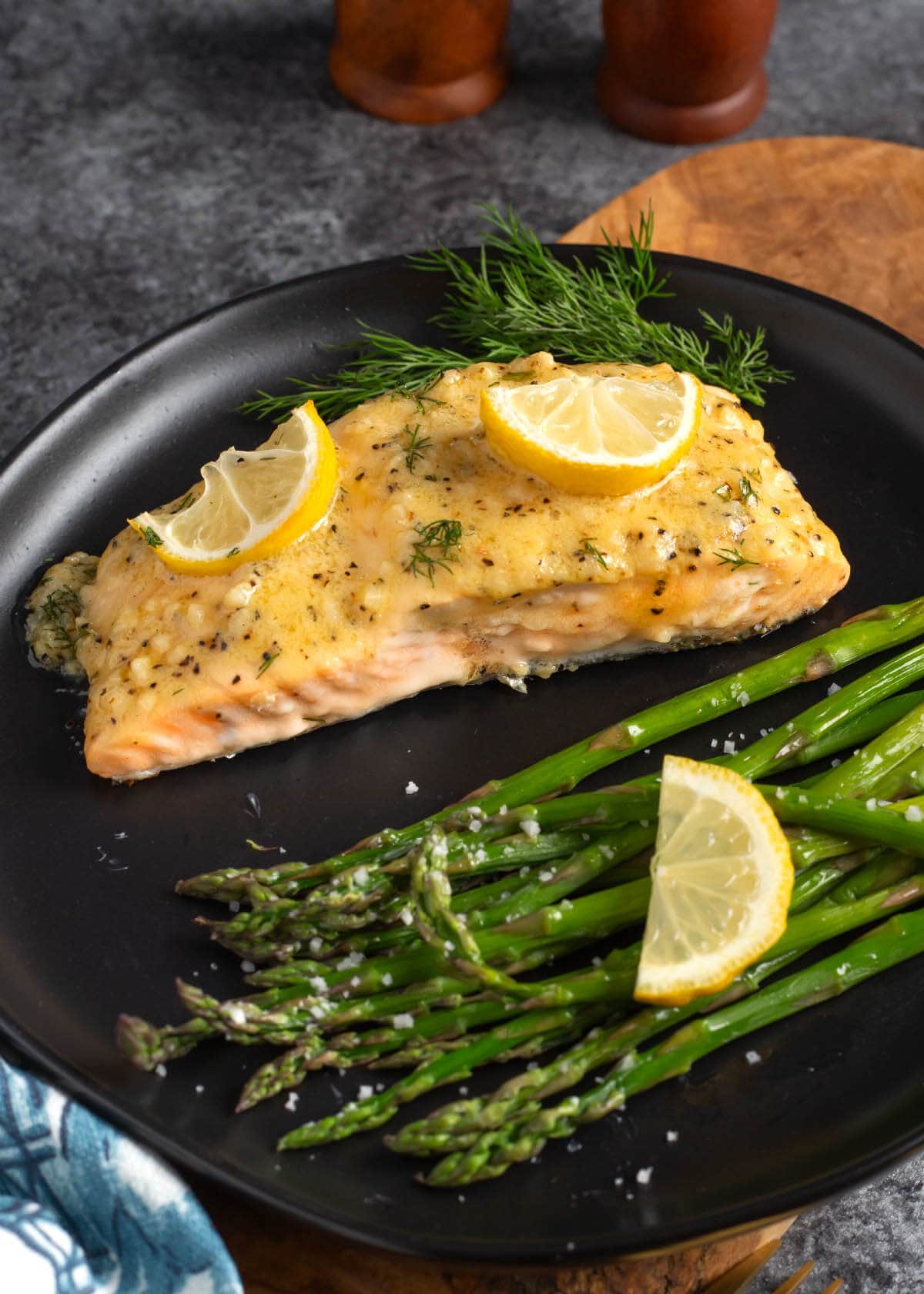 Baked Salmon Fillets and asparagus on a black plate