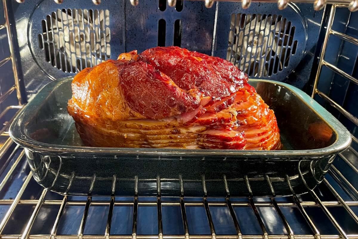 Brown Sugar Glazed Spiral Ham in a baking dish in the oven
