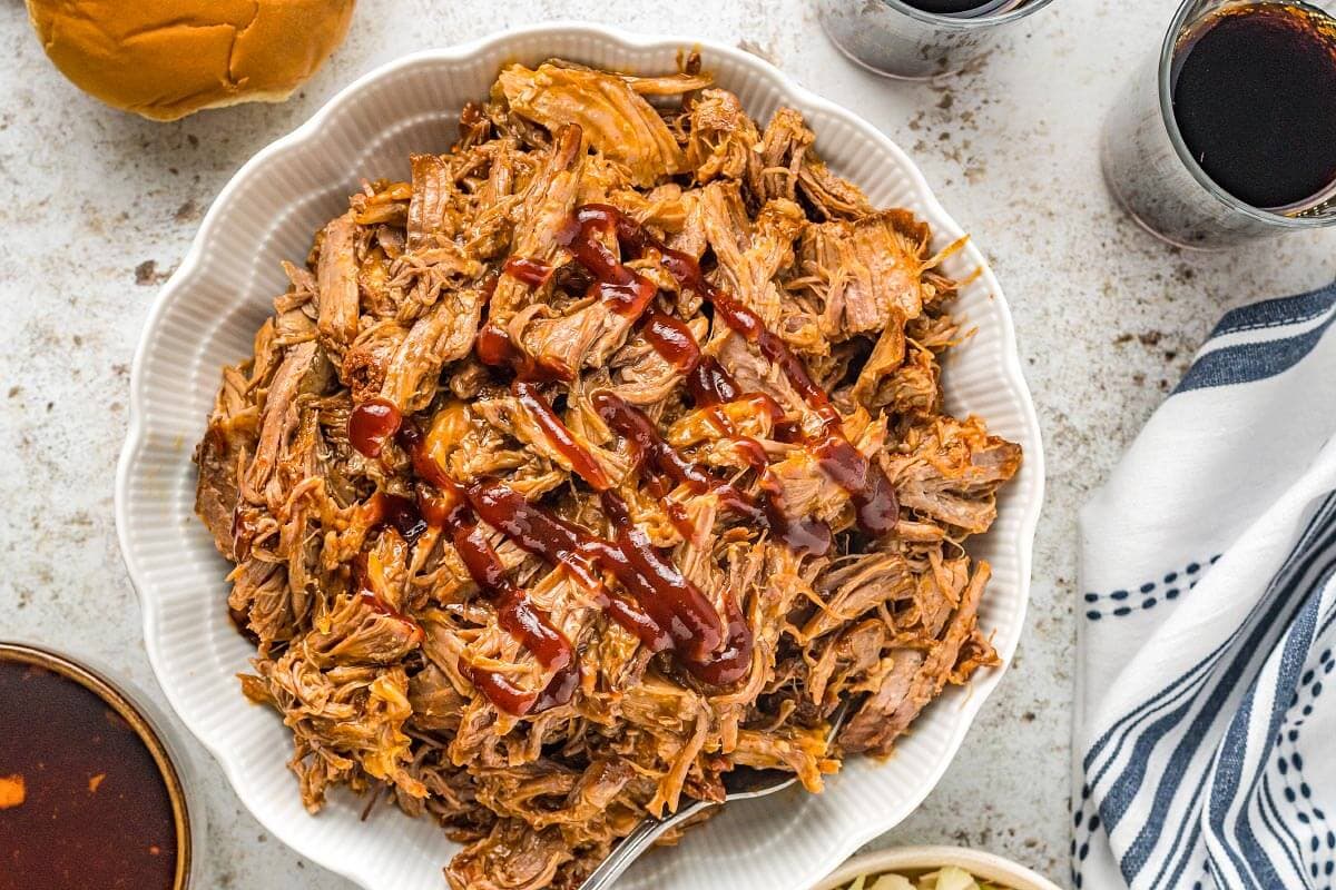 Slow Cooker Cherry Cola Pulled Pork in white dish